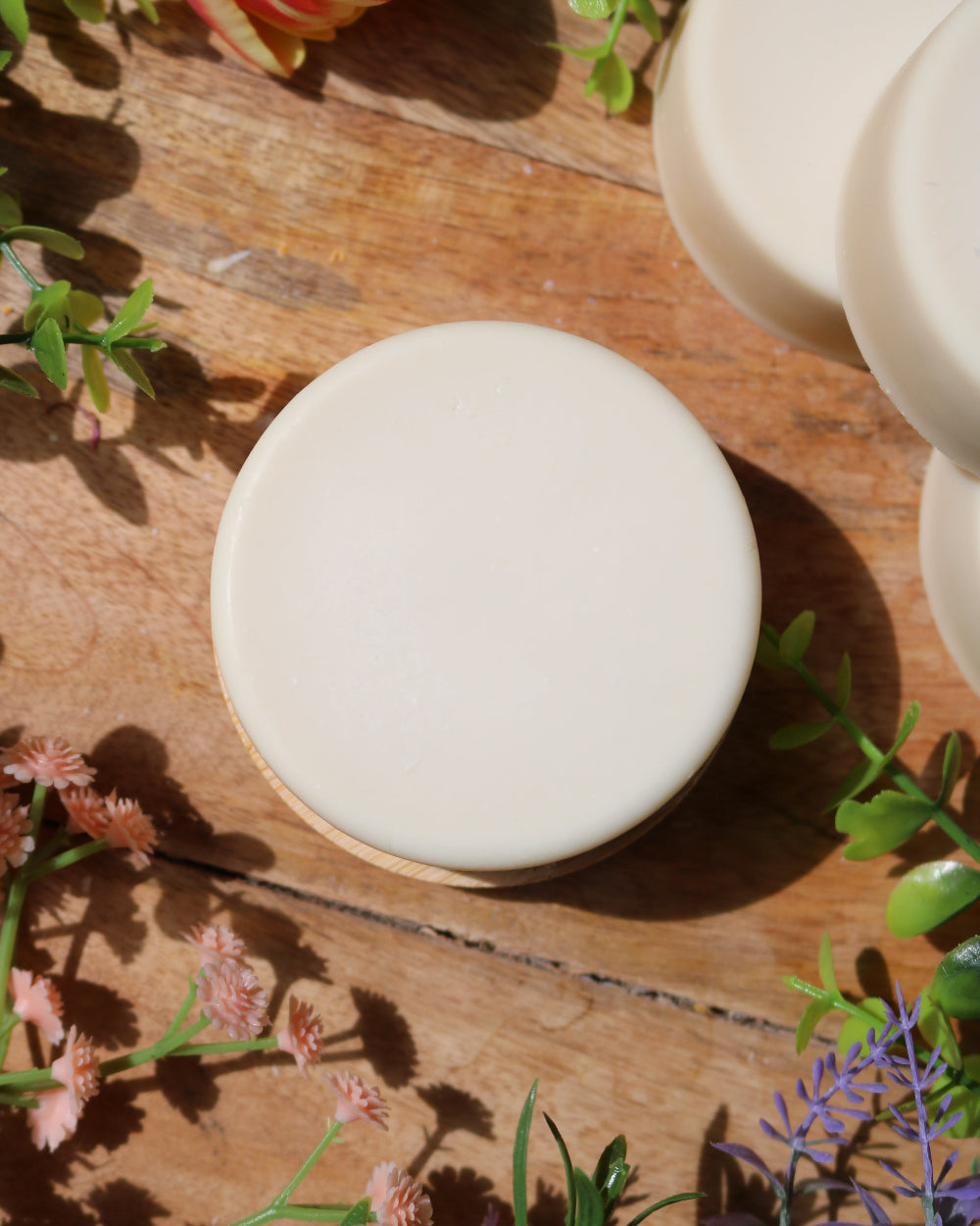 artisan soap bars on a wooden surface with greenery and flowers